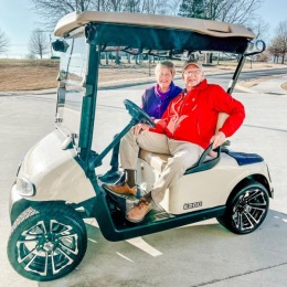 The essence of exceptional living a couple on a golf cart