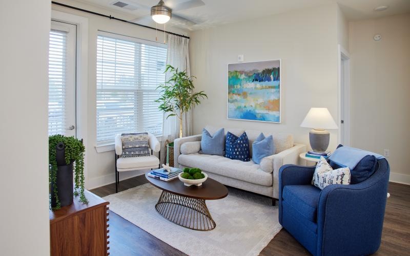 a living room with a blue chair, couch and a coffee table